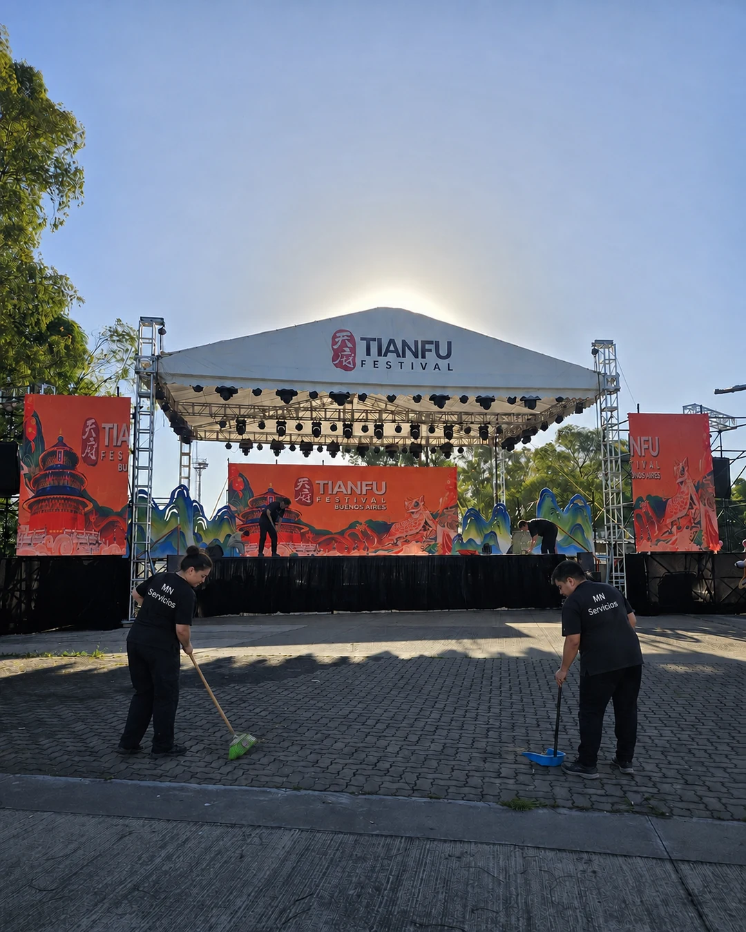 Personal de MN Servicios realizando tareas de limpieza frente al escenario de un festival